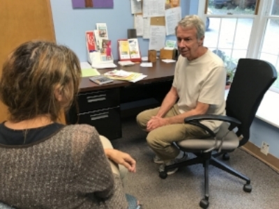 Hurricane Irma evacuee Wren (left), whose home in Ocala, Fla., was destroyed, meets with a Crisis Ministry volunteer counselor to discuss affordable housing options in Buncombe County for her family.